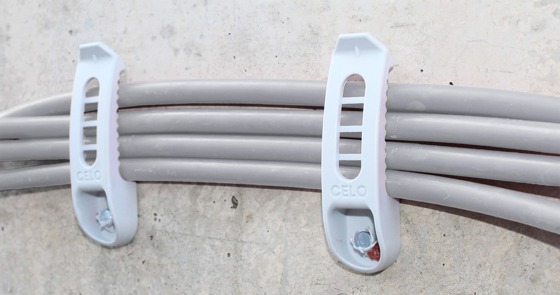 Kabel, die mit Kabelhaltern an einer Betonwand befestigt sind