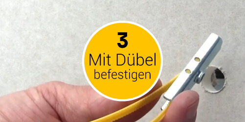 Bild für Menüpunkt 3 mit Dübeln für Gipskartonplatten befestigen: in eine Gipskartonplatte ist bereits ein Loch gebort und der Hohlraumdübel BT Plus wird vorne im Bild von einer Hand zusammengeklappt, um ihn durch das Loch zu führen