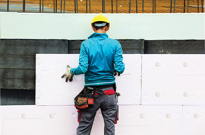 Handwerker bei der Befestigung von Dämmplattem in einer WDVS-Dämmung